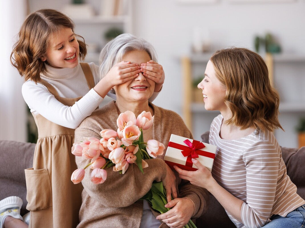 two young girls giving their grandmother the best gifts for grandma