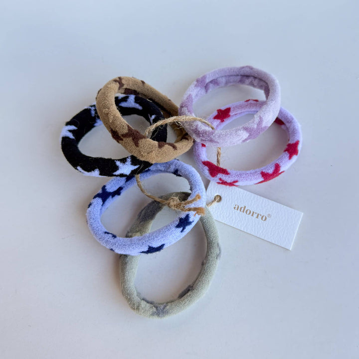 Set of colorful hair ties with a visible brand tag on a white background