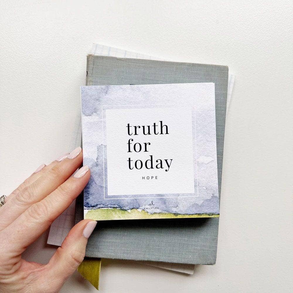 Hand holding a card titled 'truth for today' with a watercolor design on a light background