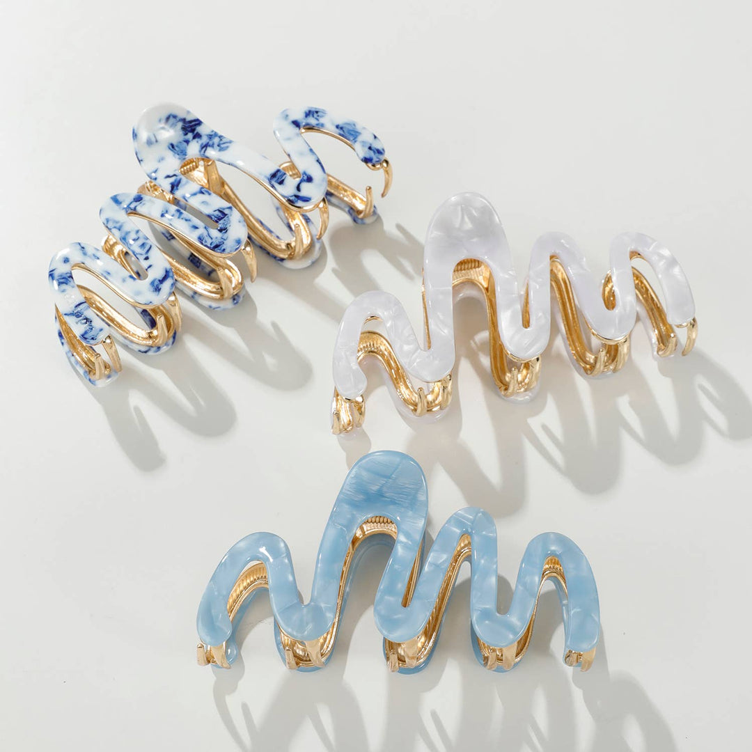 Set of decorative hair clips with blue and gold accents on a light gray background