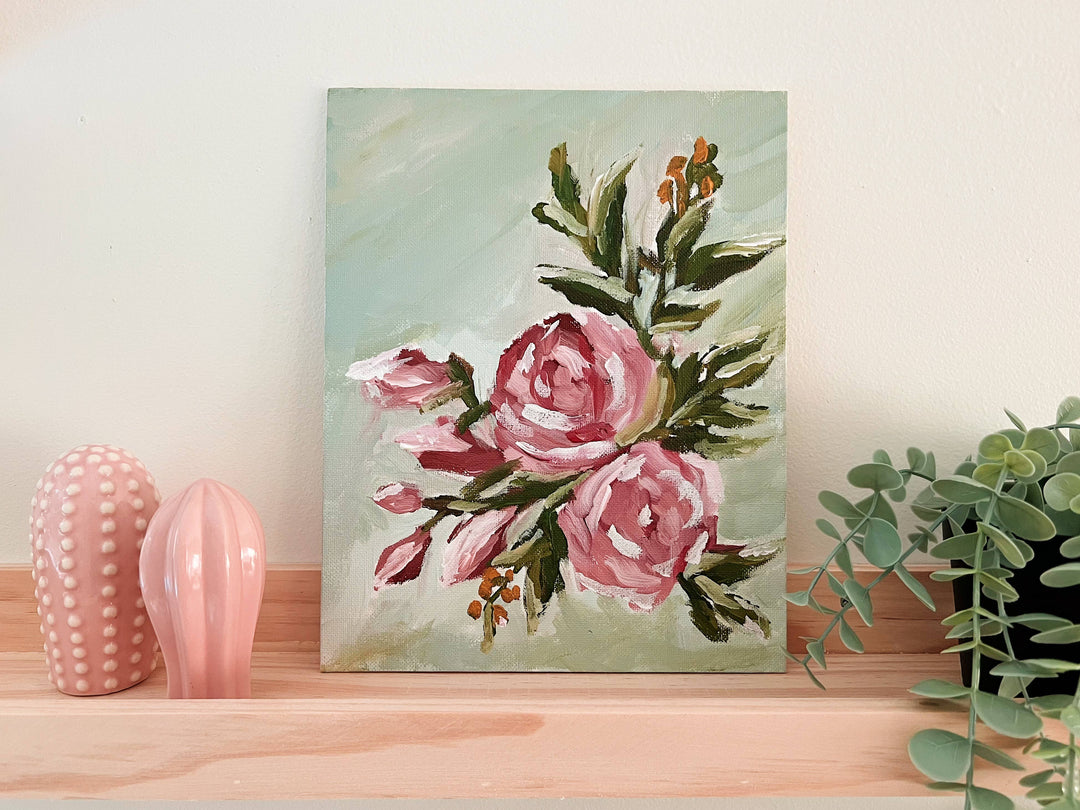 Floral painting on a wall with decorative vases and plants below.