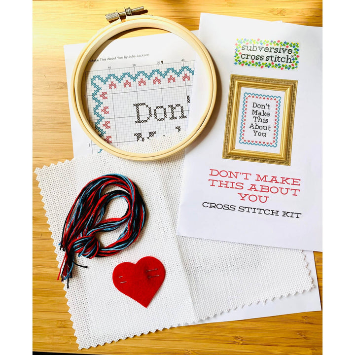 Cross stitch kit with hoop, thread, and printed instructions on a wooden surface