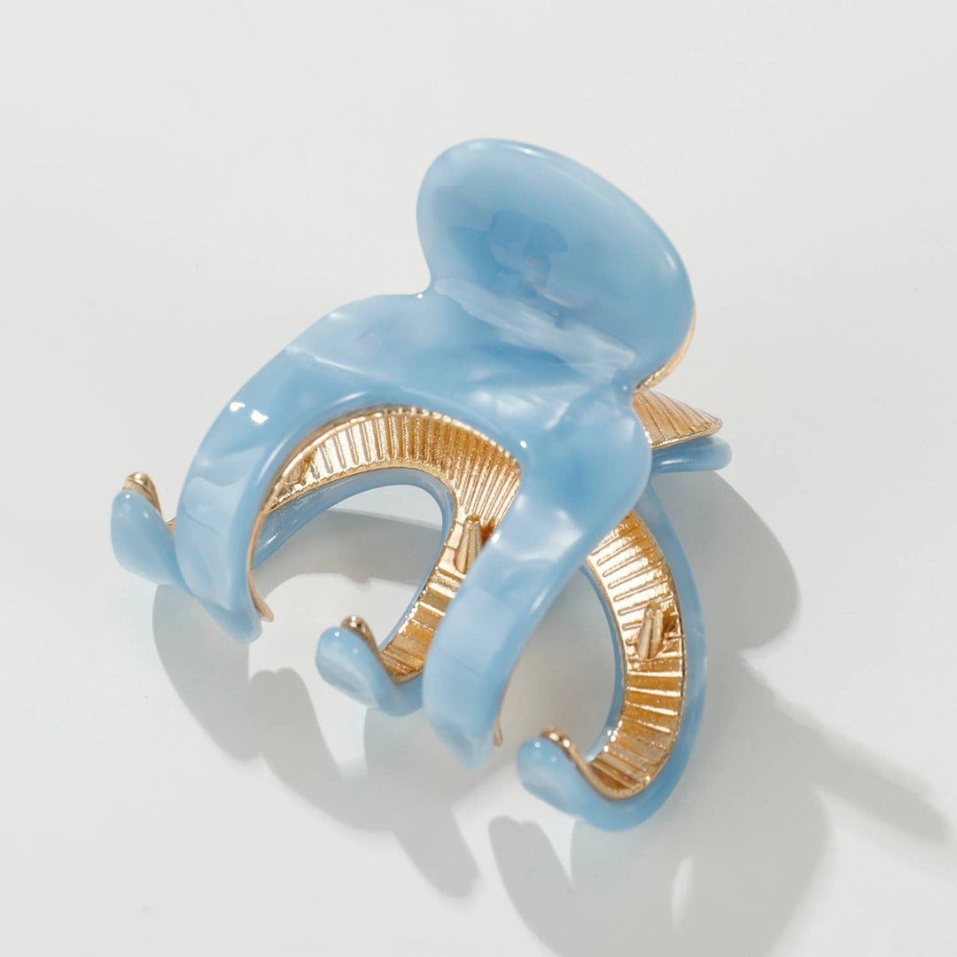 Blue and gold hair clip on a white background