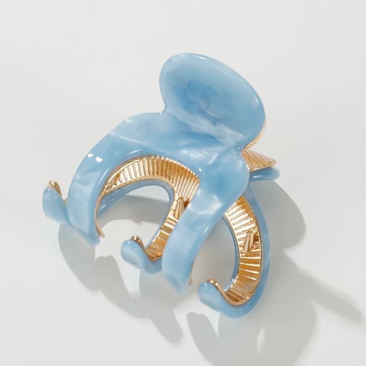 Blue and gold hair clip on a white background