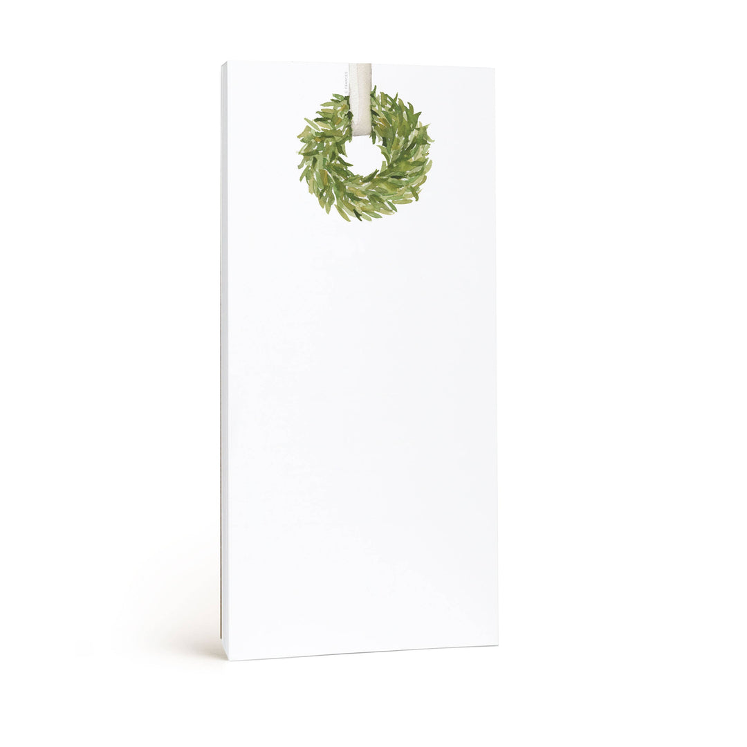Photo of white notepad with green wreath at the top.