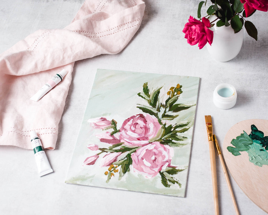 Floral painting on a table with art supplies