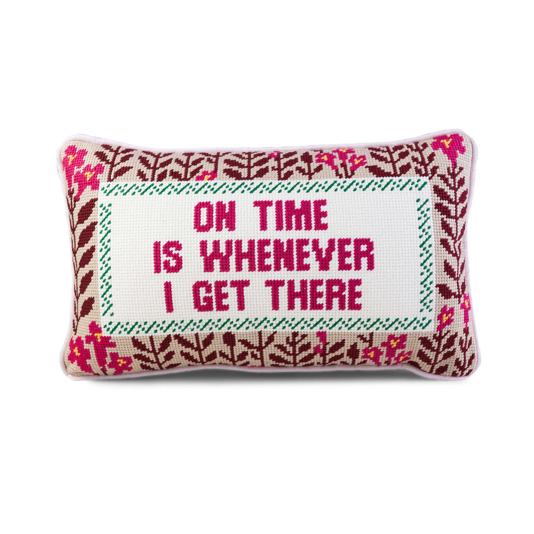 Decorative pillow with floral pattern and text 'On time is whenever I get there' on a white background