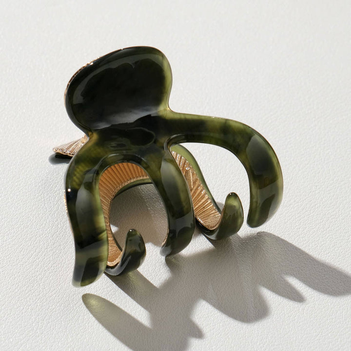 Green and brown hair clip on a light gray background
