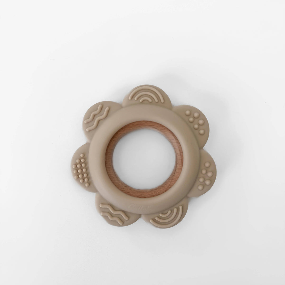 Beige teething ring with wooden center on a white background