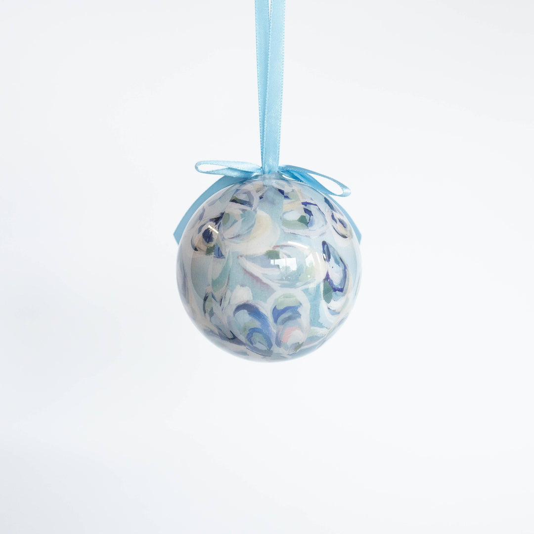 Decorative glass ball with blue ribbon on a white background