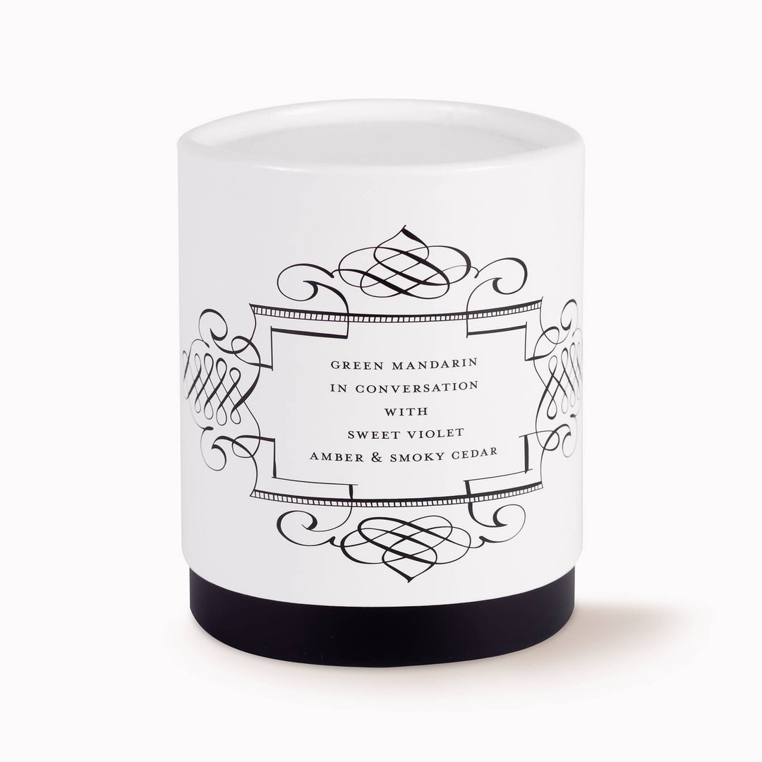 White candle with black decorative label on a white background