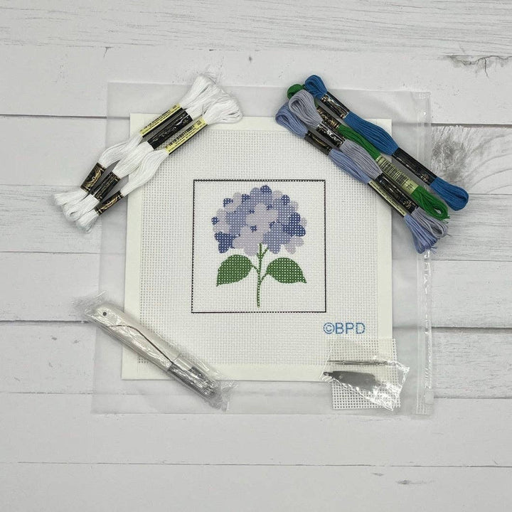 Cross-stitch kit with a completed flower design on a white background