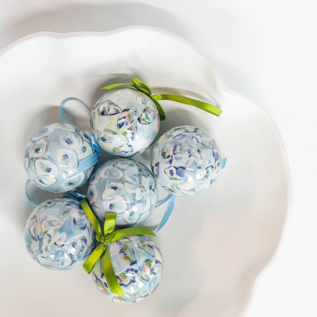 Decorative eggs with floral patterns and green ribbons on a white surface