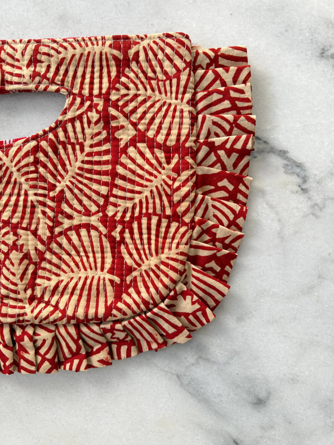 Red and white patterned clutch on a marble surface