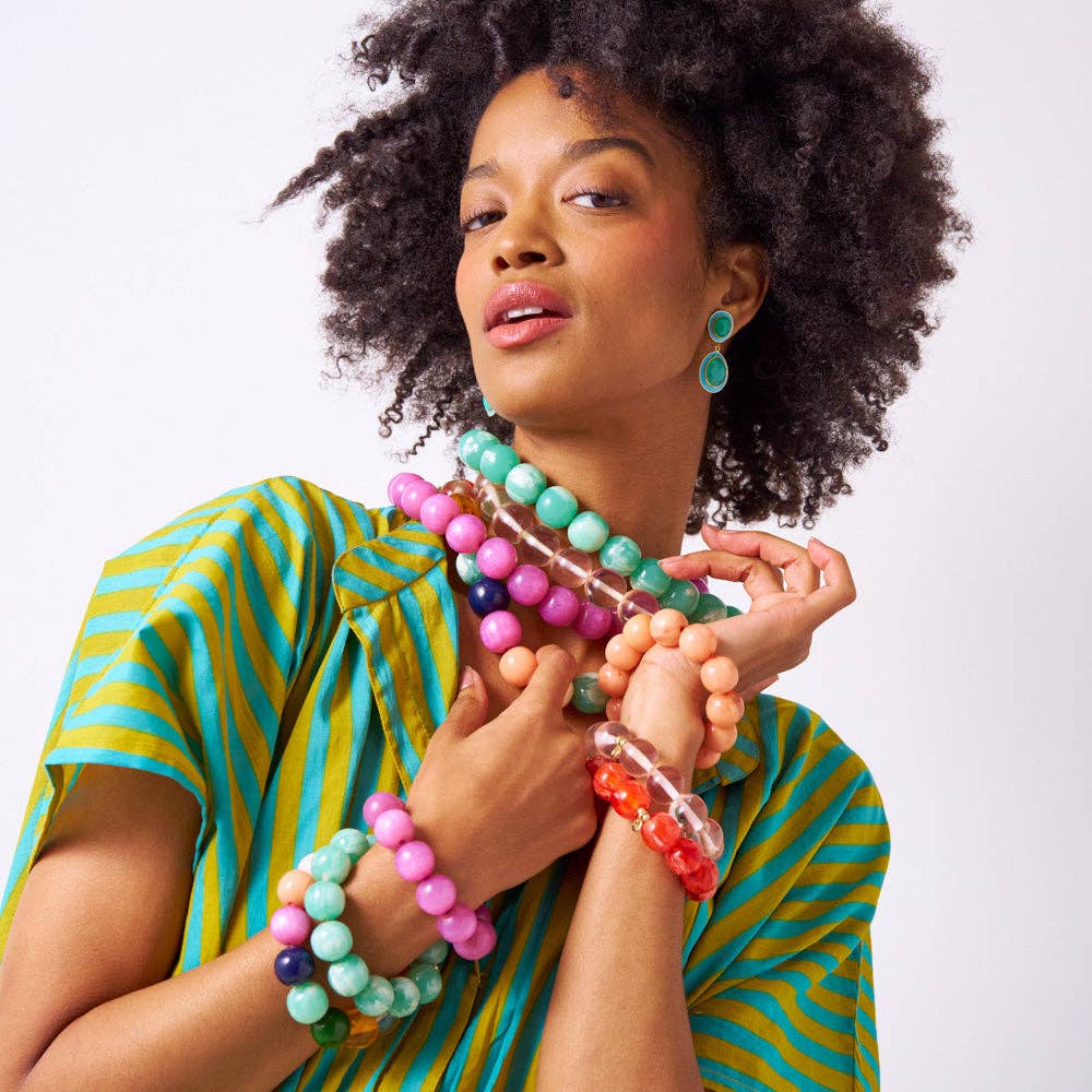 Woman wearing colorful beaded necklaces and bracelets on a white background