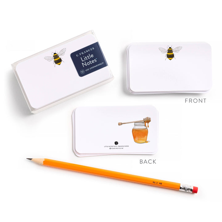 Notebook with bee and honey design, accompanied by a pencil on a white background