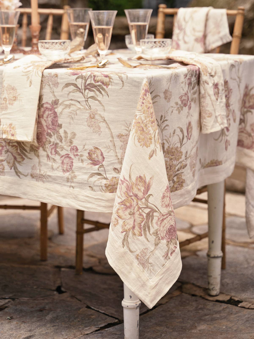 Table setting with floral tablecloth and napkins in a rustic outdoor setting