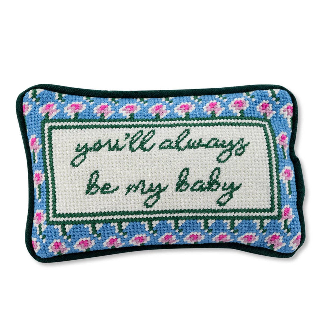 Decorative pillow with embroidered text and floral border on a white background