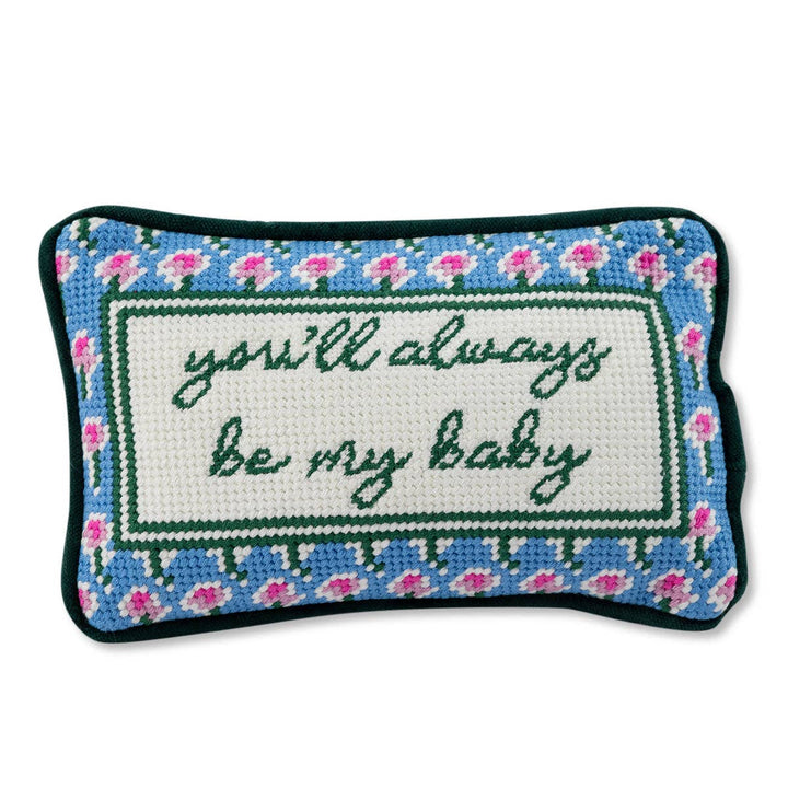 Decorative pillow with embroidered text and floral border on a white background