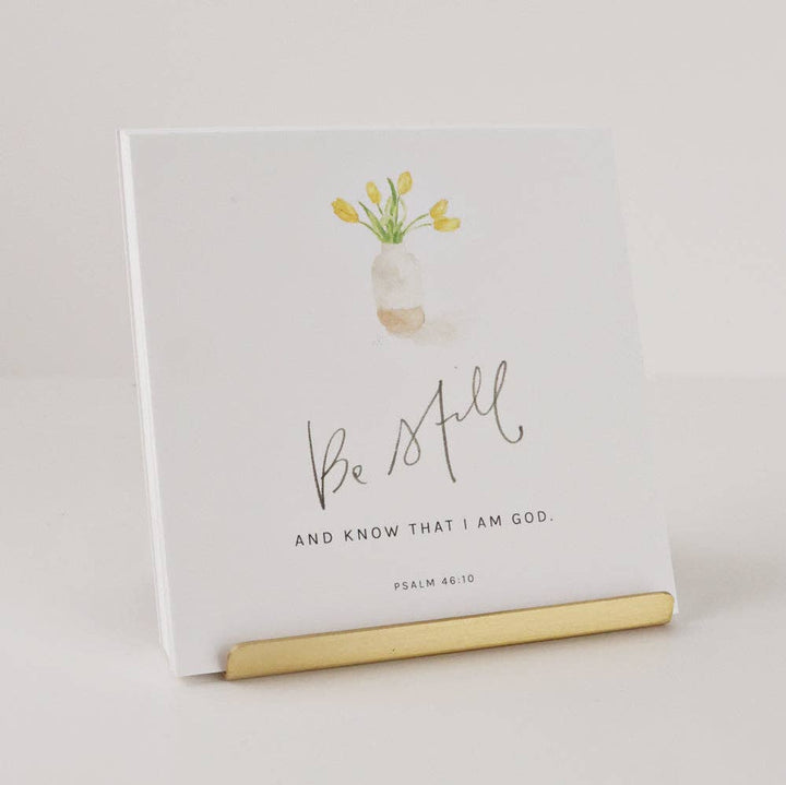 Notebook with floral design and 'Be Still' text on a light background