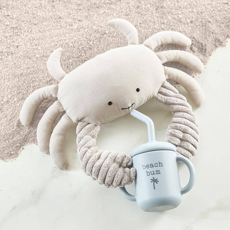 Plush crab toy with a 'beach bum' mug on sand