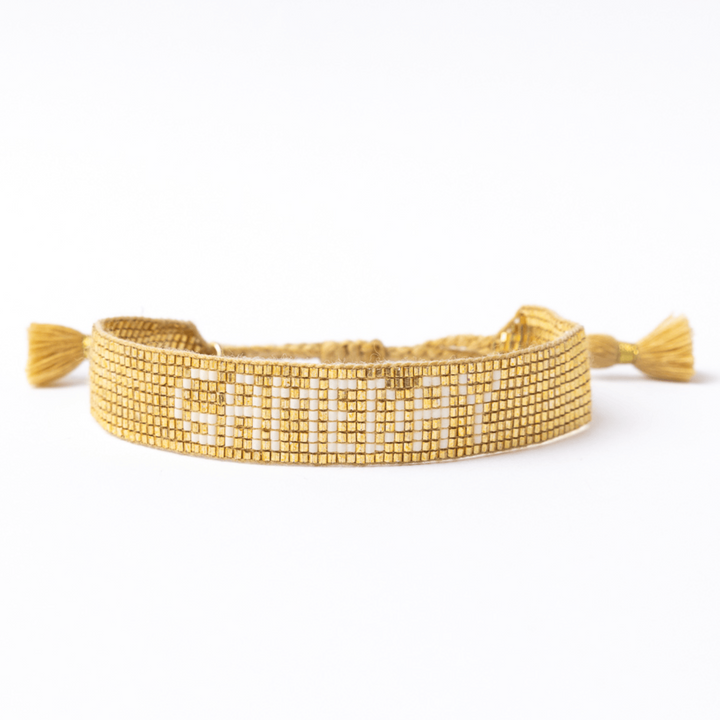 Gold bracelet with GAMEDAY text on a white background