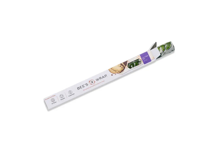 A roll of BEE'S WRAP food storage wrap, partially unrolled to show its green reflective backing, presented on a clean white background.