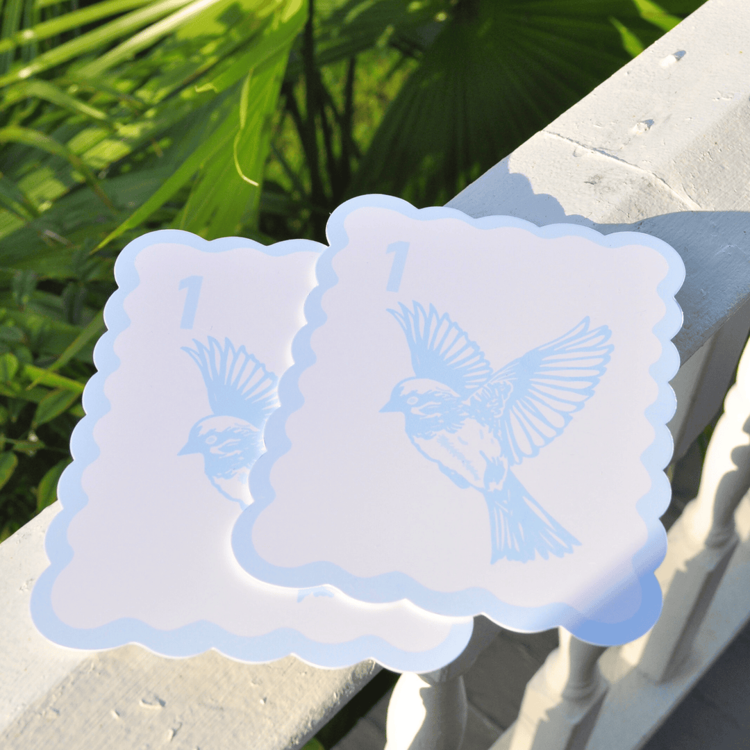 Pair of bird bam tile shufflers on a stone surface with greenery in the background