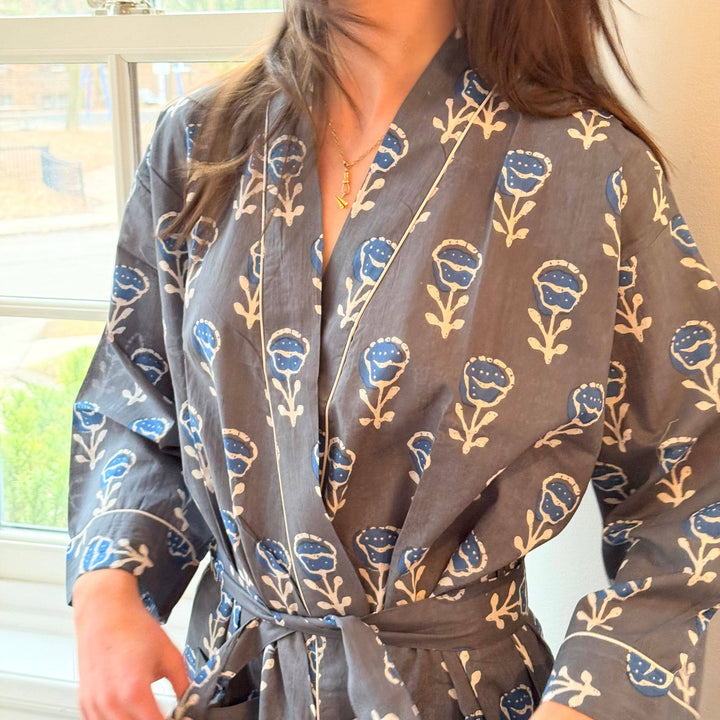 Person wearing a floral-patterned robe in a bright room.