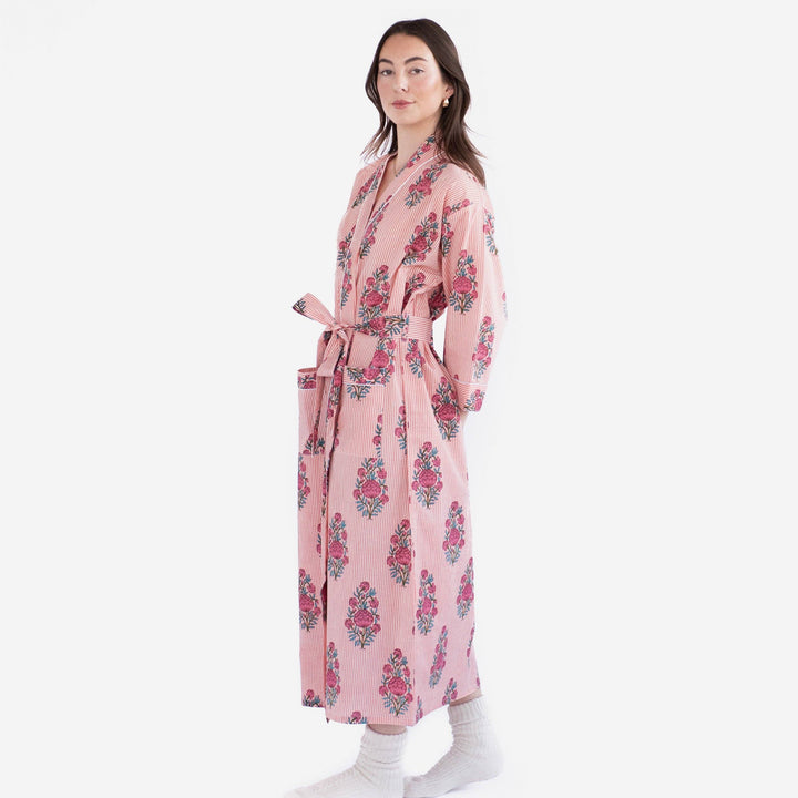 Woman wearing a pink floral robe on a white background