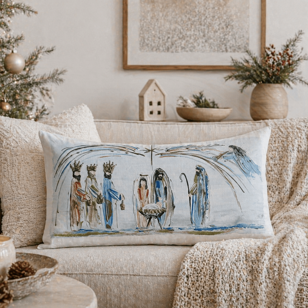 Decorative pillow with nativity scene on a couch with Christmas tree and decorations.