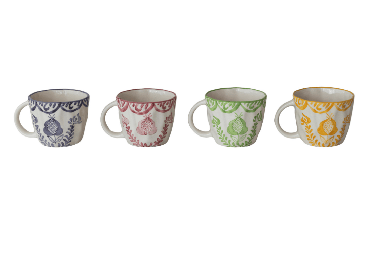 Four ceramic coffee cups lined up in a row on a white background. Each cup has a white base decorated with a botanical pattern in a different color: blue, dusty pink, green, and mustard yellow.