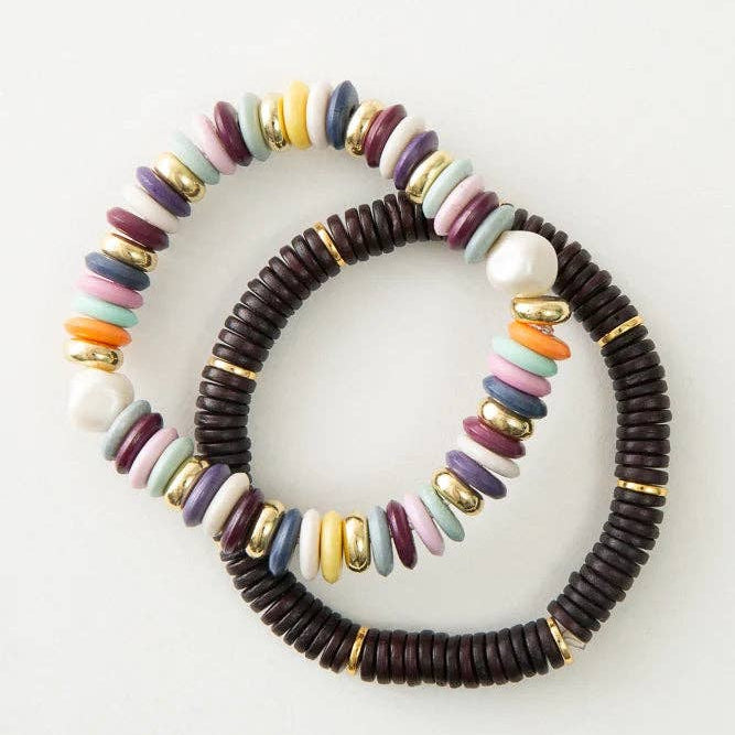 Two beaded bracelets with colorful beads and dark wood-like center on a white background