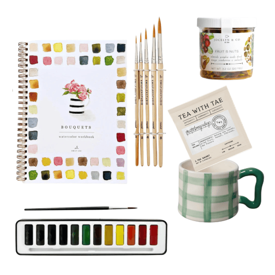 Art supplies including a watercolor notebook, paintbrushes, palette, mug, and tea packaging on a white background.