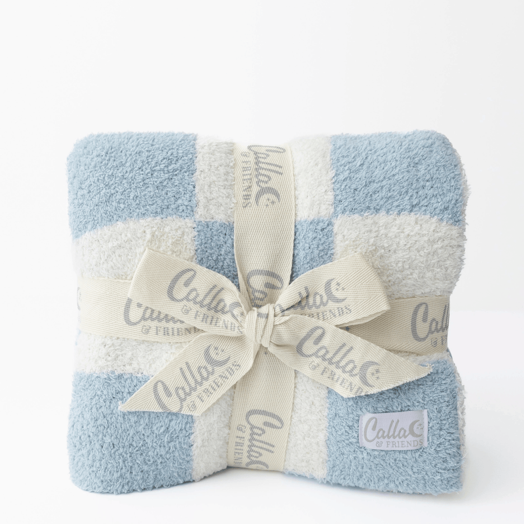 blue and white checked soft blanket folded on white background