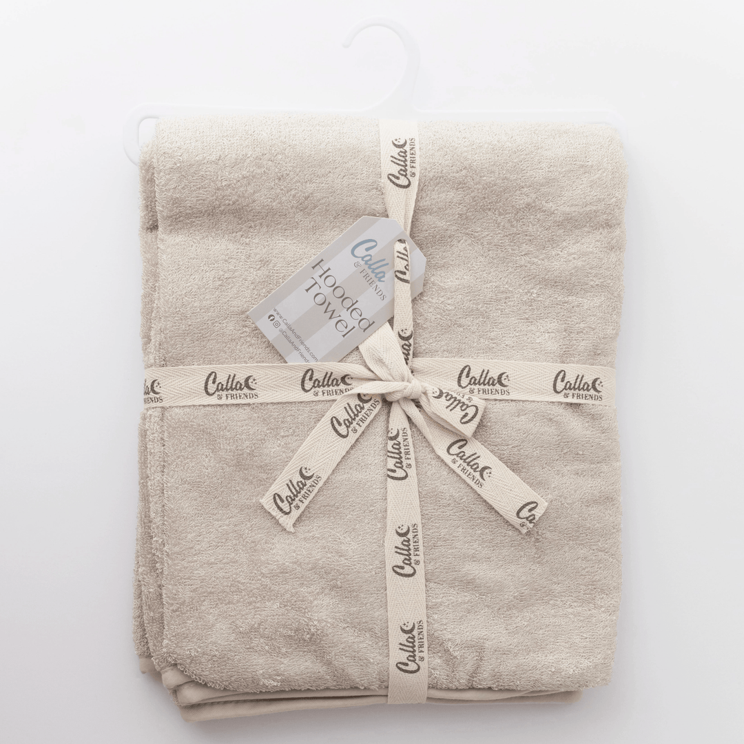 linen colored hooded baby towel folded on white background