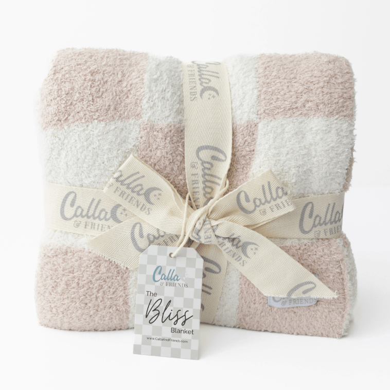Folded blanket with 'Calla & Friends' branding on a white background