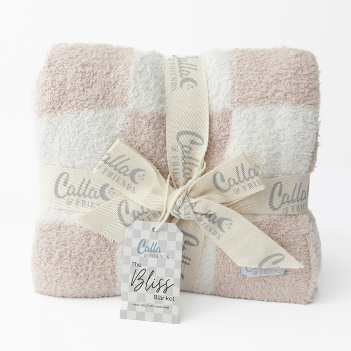 Folded blanket with 'Calla & Friends' branding on a white background