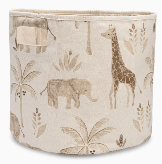 A cylindrical fabric storage bin with a safari-themed print featuring a giraffe, elephant, and palm trees in muted brown and beige tones on a cream background.