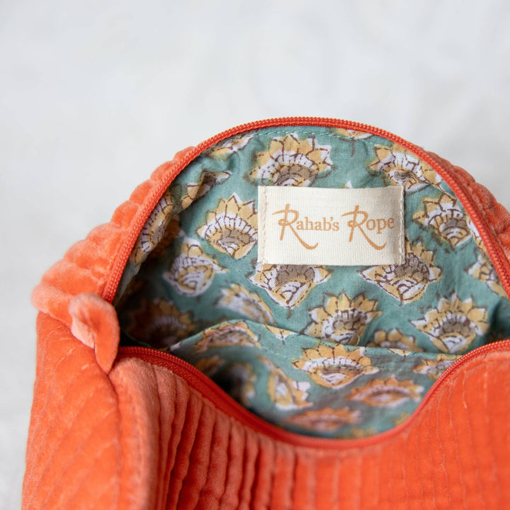 Close-up of an orange textured bag with a floral patterned interior and 'Kahala Rope' label.