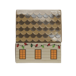 A small decorative house-shaped match box, featuring a brown scalloped roof, beige siding, three orange windows, and red and green holiday lights along the roofline, shown on a plain white background.