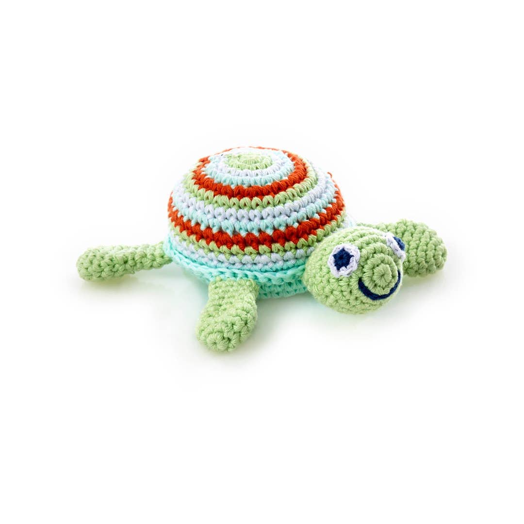 Crocheted turtle toy with striped shell on a white background