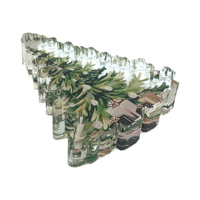 Acrylic napkin weight shaped like a decorated christmas tree with presents at the bottom 
