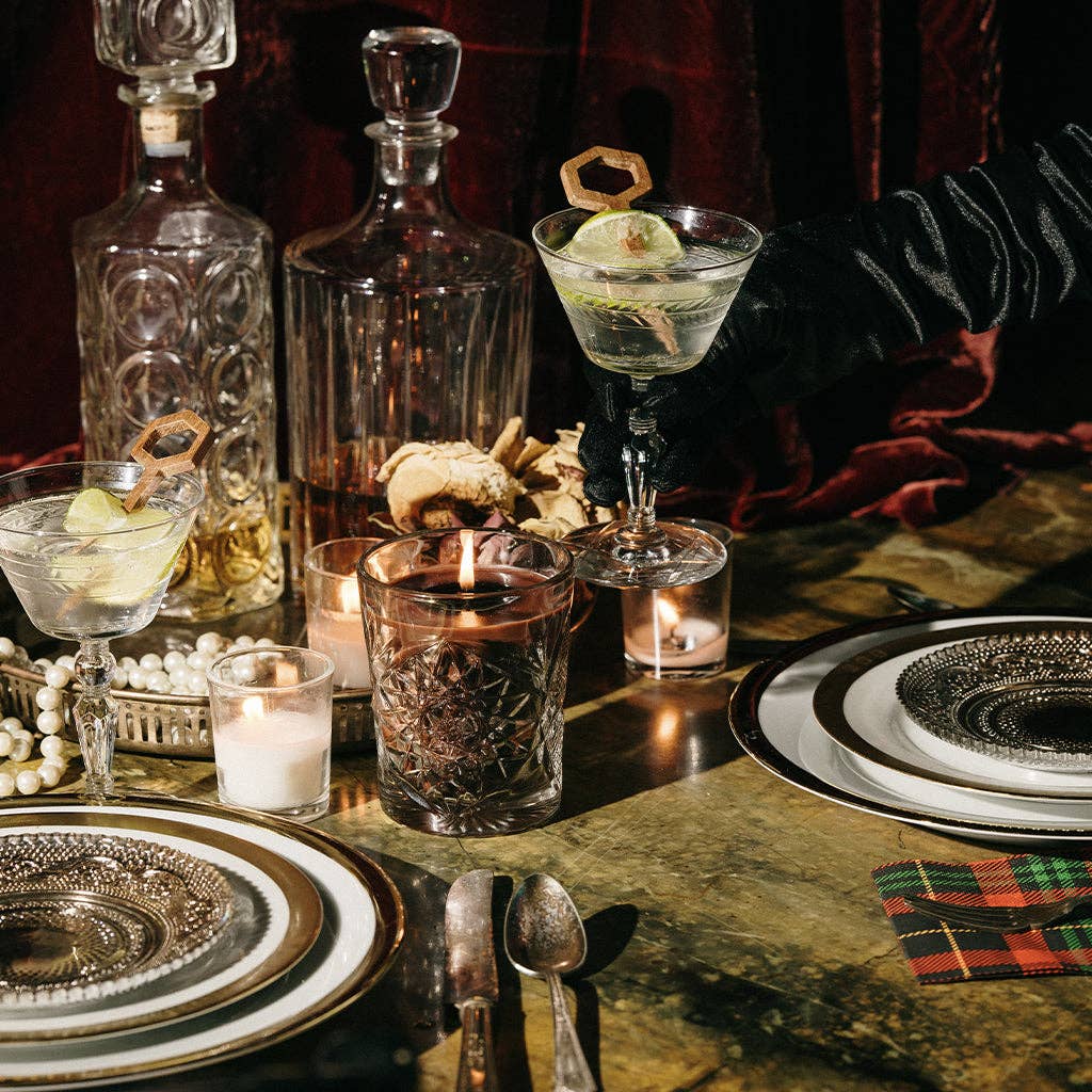 Dinner table setting with decanters, glasses, and candles in a cozy atmosphere with dinner date candle in the center.