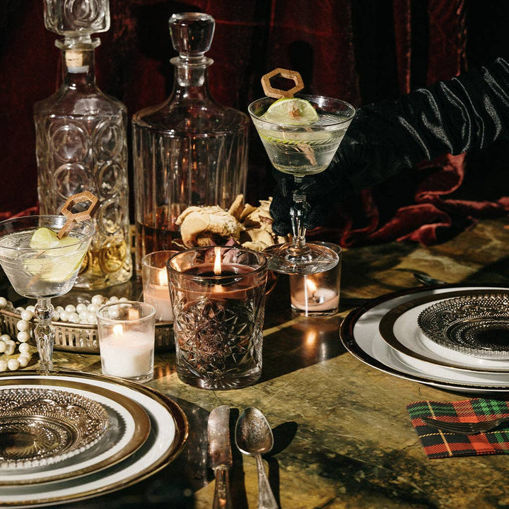 Dinner table setting with decanters, glasses, and candles in a cozy atmosphere with dinner date candle in the center.