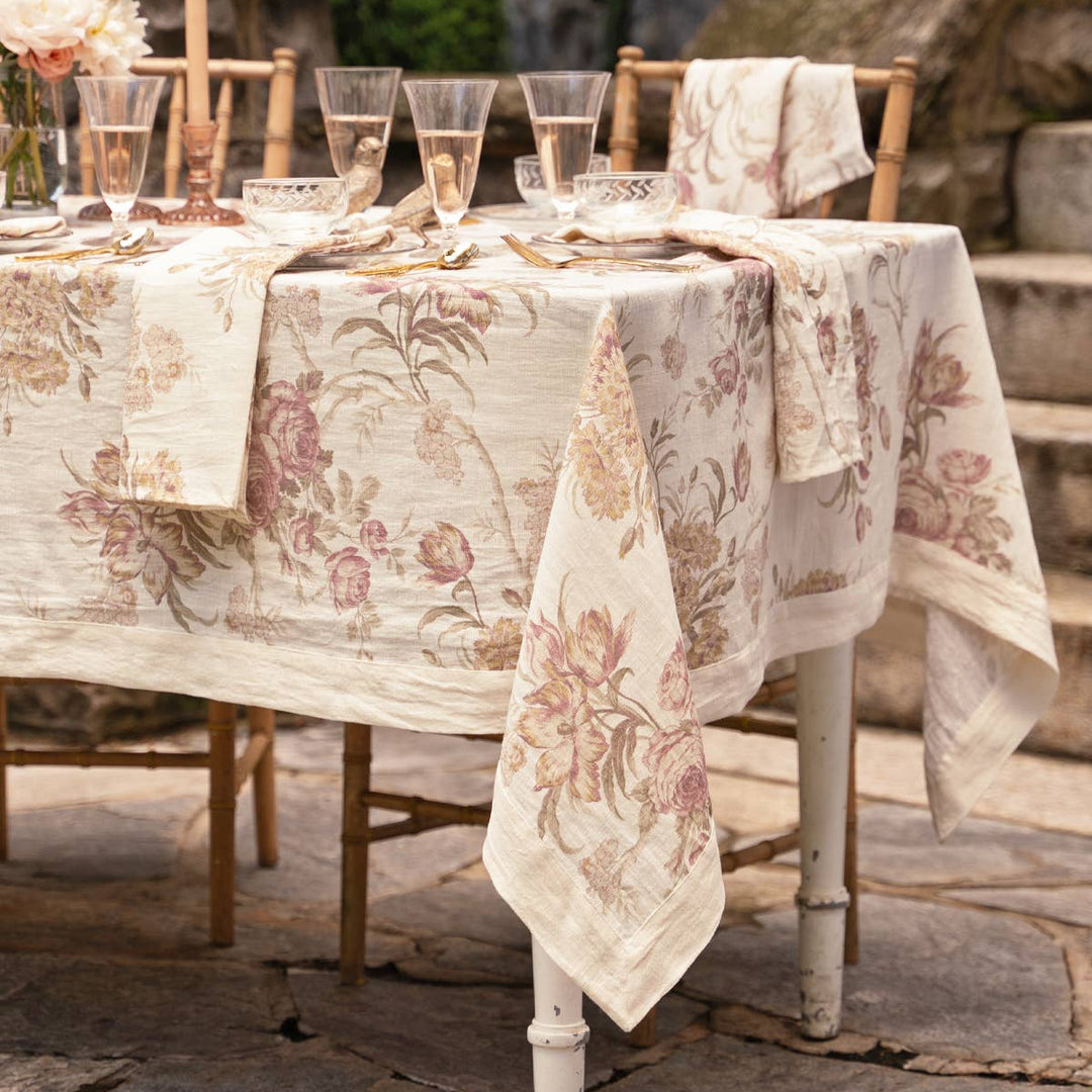 Decorative table setting with floral tablecloth and napkins outdoors.
