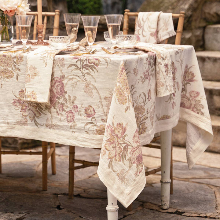 Decorative table setting with floral tablecloth and napkins outdoors.