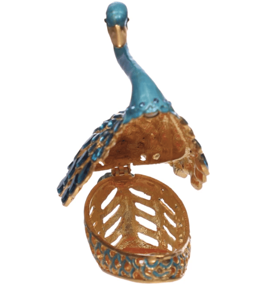 Add a touch of graceful elegance to any room setting with this gold-finished Swan-Shaped Trinket Box, crafted in smooth enamel and adorned with blue highlights and shimmering glass jewels. The sculptural form evokes timeless charm while offering functional storage for treasured objects. Perfectly suited to French Country, Traditional, Farmhouse, or Glam Cottagecore interiors, it brings an air of refined whimsy to shelves, vanities, or nightstands.