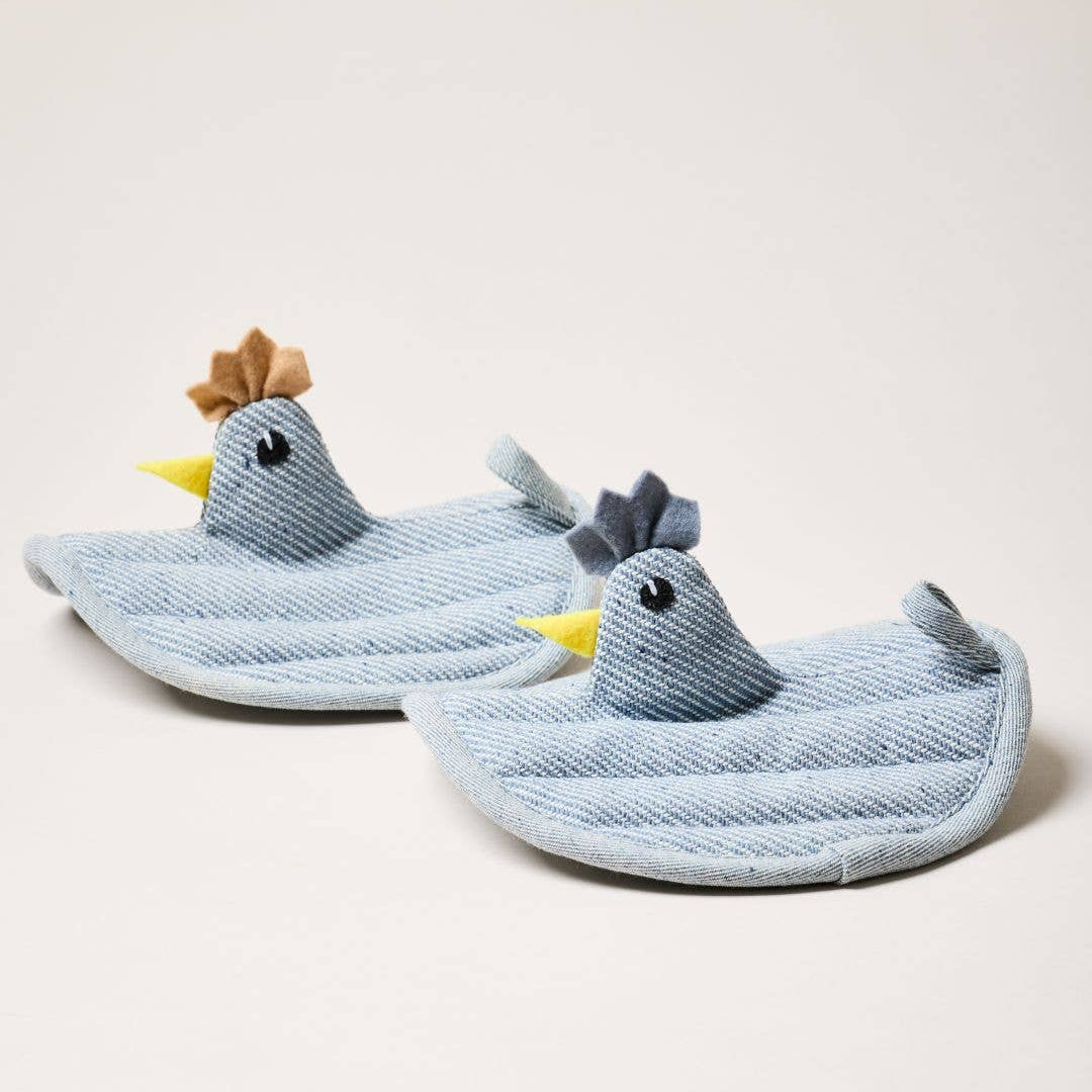 Two blue hen potholders on a light beige background