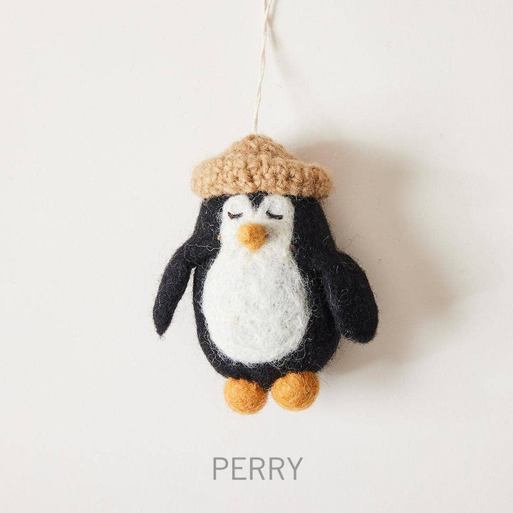Knitted penguin ornament with a hat on a white background